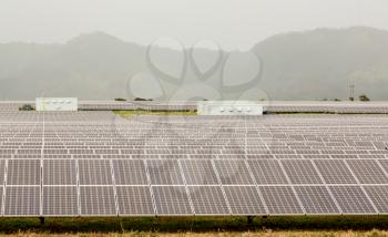 Rows of solar panels in power station array on a misty and cloudy day near Koloa, Kauai, Hawaii