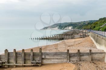 View along pebbly beach of Eastbourne towards white cliffs of Beachy Head on cloudy day