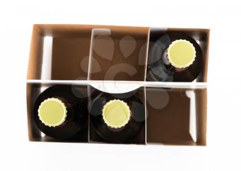 Pattern of three beer bottles in six pack cardboard container with gold caps facing upwards