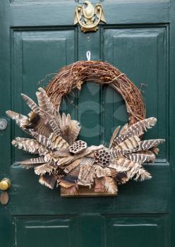 Traditional design of a christmas wreath attached to the front door of old house
