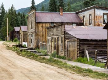 Old wooden houses line the main street of ghost town of St Elmo in Colorado