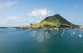 Bay and harbour at Tauranga with yachts and boats in the blue calm water in front of the Mount