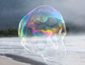 Man making multiple giant soap bubbles on Hanalei beach in Kauai Hawaii