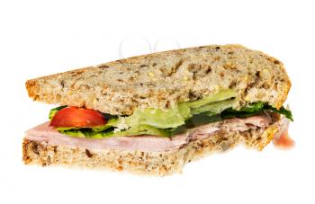 Isolated image of an english ham lettuce and tomato sandwich with a bite out of one corner. Bread is artisan multigrain wheat