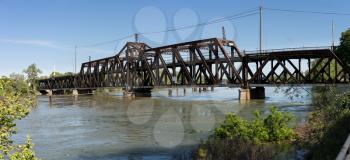 Metal truss swing bridge called I St Bridge across flooded Sacramento River in capital of California