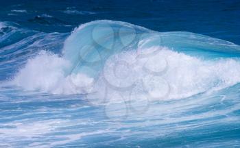 Cresting ocean waves taken with high shutter speed to show droplets of water in the surf