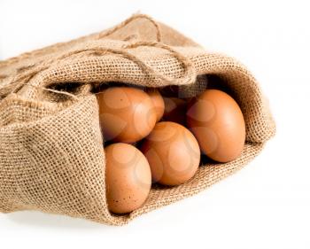 Easter background with brown organic eggs arranged in burlap sack and isolated against white background