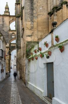 Old man walks past Church of Santa Maria in Arcos de la Frontera near Cadiz in Spain