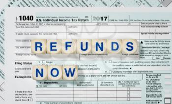 Close macro photo of USA IRS tax form 1040 for year 2017 taken from above with REFUNDS NOW spelled out in letters on the form