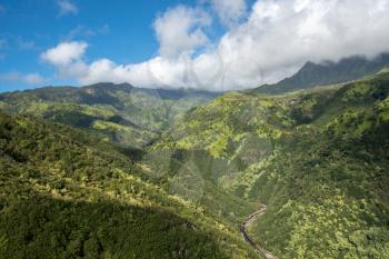 Aerial view of Manawaiopuna Falls and landscape of hawaiian island of Kauai from helicopter flight