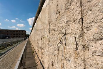 Concrete top of the Berlin Wall in Germany against a bright blue sky