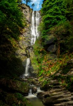 High falling water in waterfall and cascades at head of Pistyll Rhaeadr falls in Wales