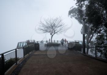 FUNCHAL, MADIERA - MARCH 12, 2018: Tourists lost in mist at Cabo Girao sea cliff near Funchal on Madiera