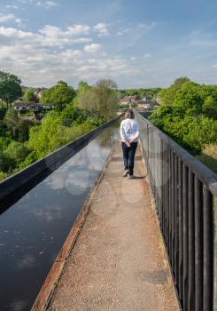 Tourist on the top of old Pontcysyllte Aqueduct near Chirk carrying Llangollen Canal across river Dee