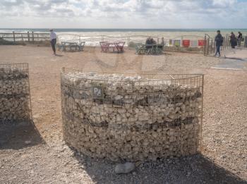 Basket holding beach pebbles and stones as a disabled parking sign at Birling Gap, Sussex