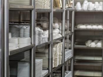 Plates and other pottery ready for service in kitchen in restaurant