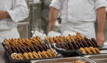 Chef finishing baked cookies in commercial stainless steel kitchen