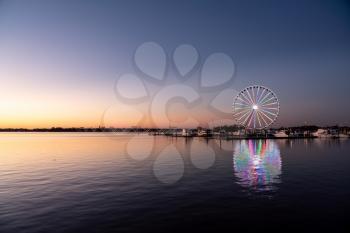 Illuminated ferris wheel at National Harbor near the nation capital of Washington DC at sunset