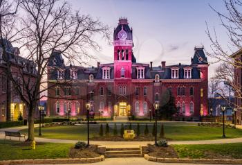 Dramatic image of Woodburn Hall at West Virginia University or WVU in Morgantown WV as the sun sets behind the illuminated historic building