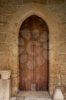 Solid wood and reinforced arched door inside historic monastery in Guimaraes