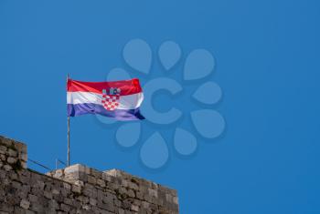 Flag of Croatia or the Tricolour flies on the stone walls of Dubrovnik