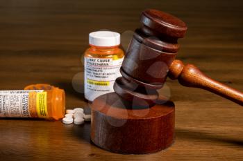 Oxycodone is the generic name for opoid pain killing tablets. Prescription bottle for pills and tablets with judge's gavel for court decision