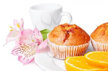 Two muffins, orange and flowers on a white background