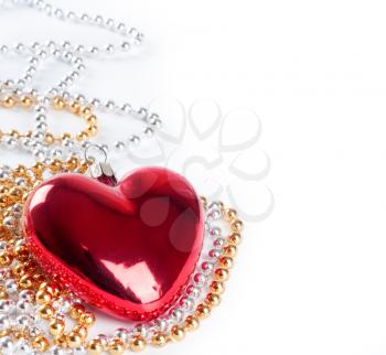 Red heart and golden beads on a white background