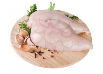 Raw chicken fillet on board with parsley and garlic