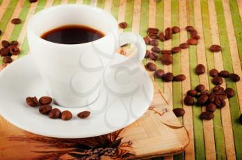 Vintage background with coffee cup and coffee beans  on green bamboo stand