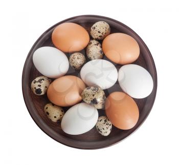 Quail and chicken eggs in a clay plate isolated on a white background