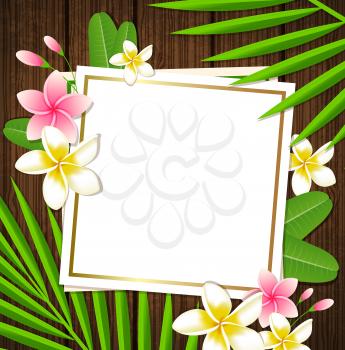 Decorative floral frame with tropical flowers and palm leaves on a wooden background