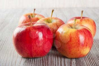 Ripe red apples on a wooden background. 