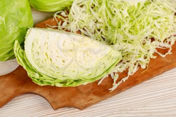 Fresh white cabbage and chopped cabbage for salad on a wooden cutting board. Vegetarian and healthy diet food concept. Top view