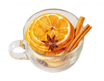 Stack of dried orange slices, cinnamon and star anise in a glass cup. Spices for mulled wine on a white background. Top view