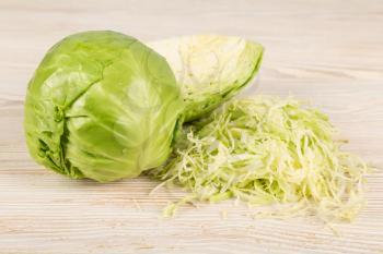 Fresh white cabbage and chopped cabbage on a wooden background. Vegetarian and diet food concept. 