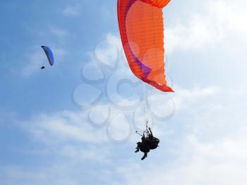 Paraglider is flying in the blue sky