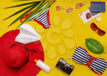 top view set of women's beach accessories and things for relaxation on a bright yellow background