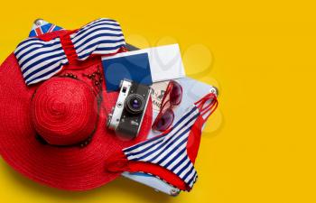 top view set of women's beach accessories and things for relaxation on a bright yellow background