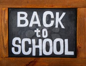 old dark chalk board in a wooden frame and the inscription Back to School, carved from a checkbook