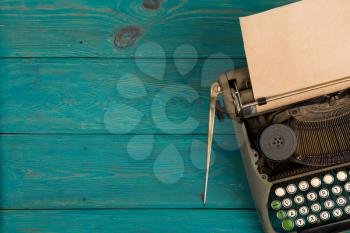 Vintage typewriter on the blue wooden desk 