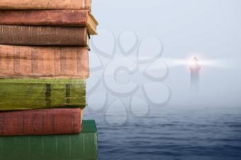 Wisdom concept - stack of books over sea and lighthouse background