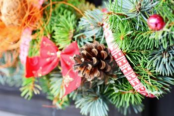 Closeup shot with Christmas decoration wreath and pine cone.