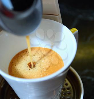 Closeup shot of an hot fresh espresso pouring to the cup  in espresso machine.