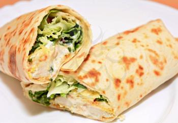 Tortilla wraps with chicken nuggets, fresh vegetable and salad.