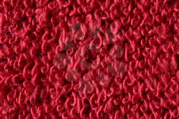 Red fabric with structured and knitted fibres extreme close up. Fabric texture. Fabric background. Knitted fabric texture.