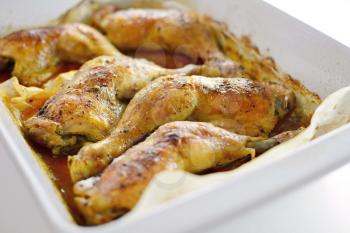 Close Up of a Roasted Chicken Drumsticks in a Roasting Pan.