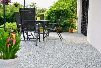 Beautiful Terrace with Decorative Natural Stone Floor, Potted Flower and Table with Chairs.