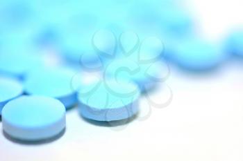Macro of a Blue Pills on the White Background.