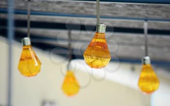 Closeup of hanging orange party bulbs on terrace roof. 